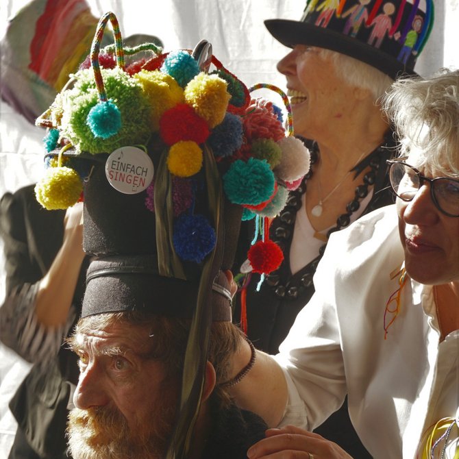 4 Menschen mit buntgeschmückten Hüten im Halbprofil